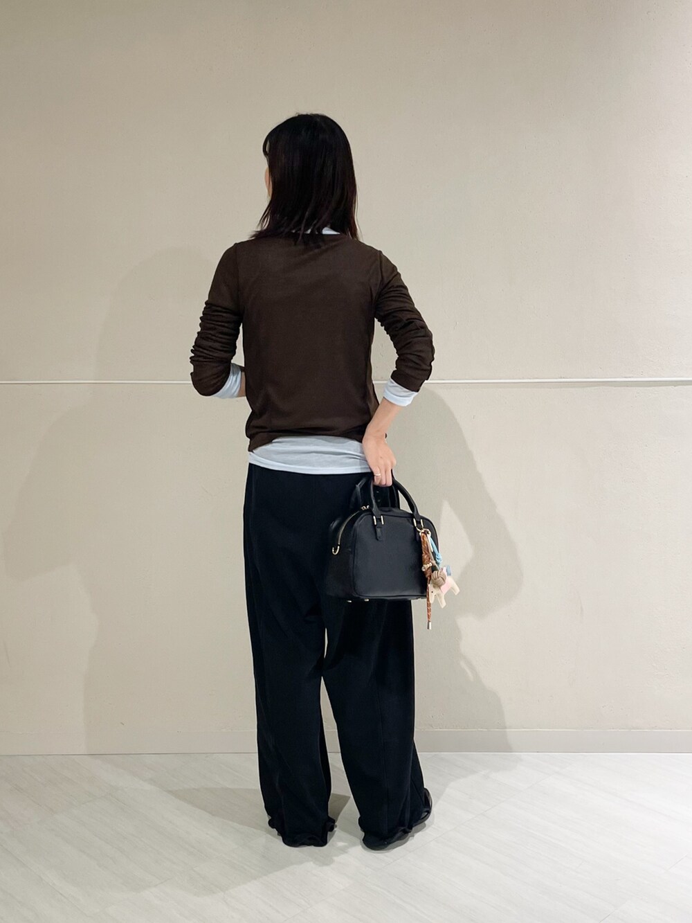 ブラック系のボストンバッグ、ブラック系のその他パンツ、ブラック系のレインシューズを着用したレディースの秋コーディネートの6枚目の写真