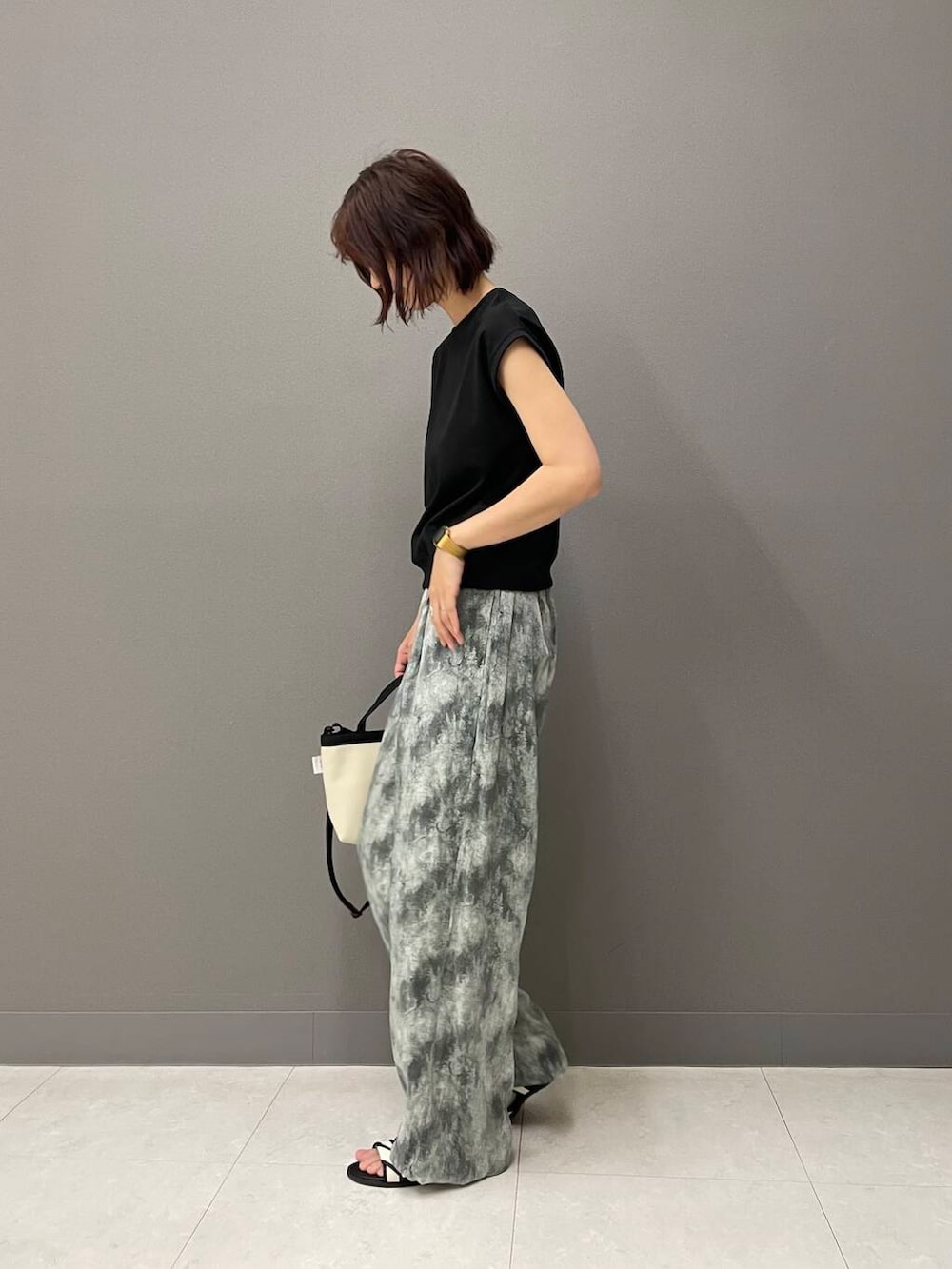 ホワイト系のサンダル、ブラック系のTシャツ/カットソー、ホワイト系のショルダーバッグを着用したレディースの夏コーディネートの3枚目の写真