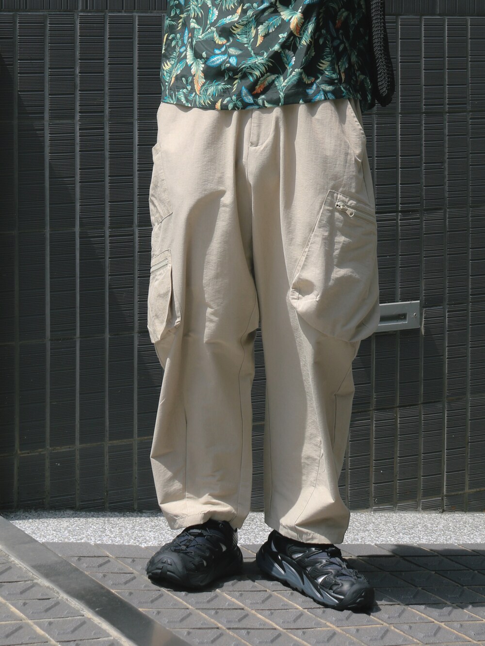 グリーン系のTシャツ/カットソー、ベージュ系のチノパンツ、ブラック系のサンダルを着用したメンズの夏コーディネートの3枚目の写真