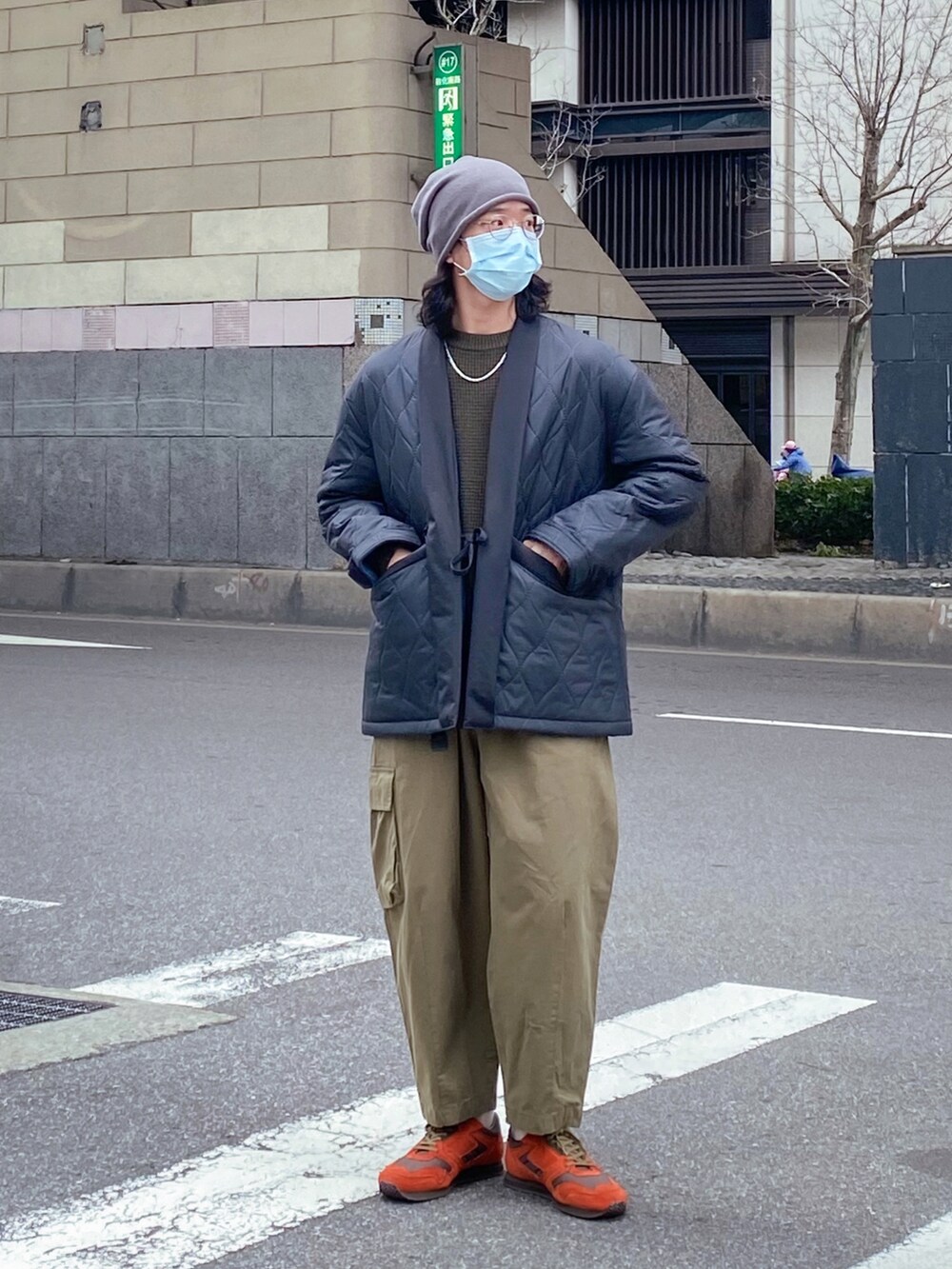 ブラック系のジャケット/アウター、グリーン系のチノパンツ、グリーン系のスニーカーを着用したメンズの冬コーディネートの2枚目の写真