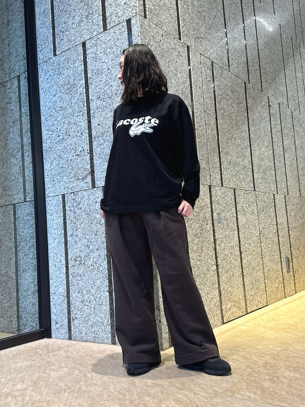 ブラック系のTシャツ/カットソー、ブラウン系のスウェットパンツ、ブラック系のスニーカーを着用したレディースの秋コーディネートの2枚目の写真