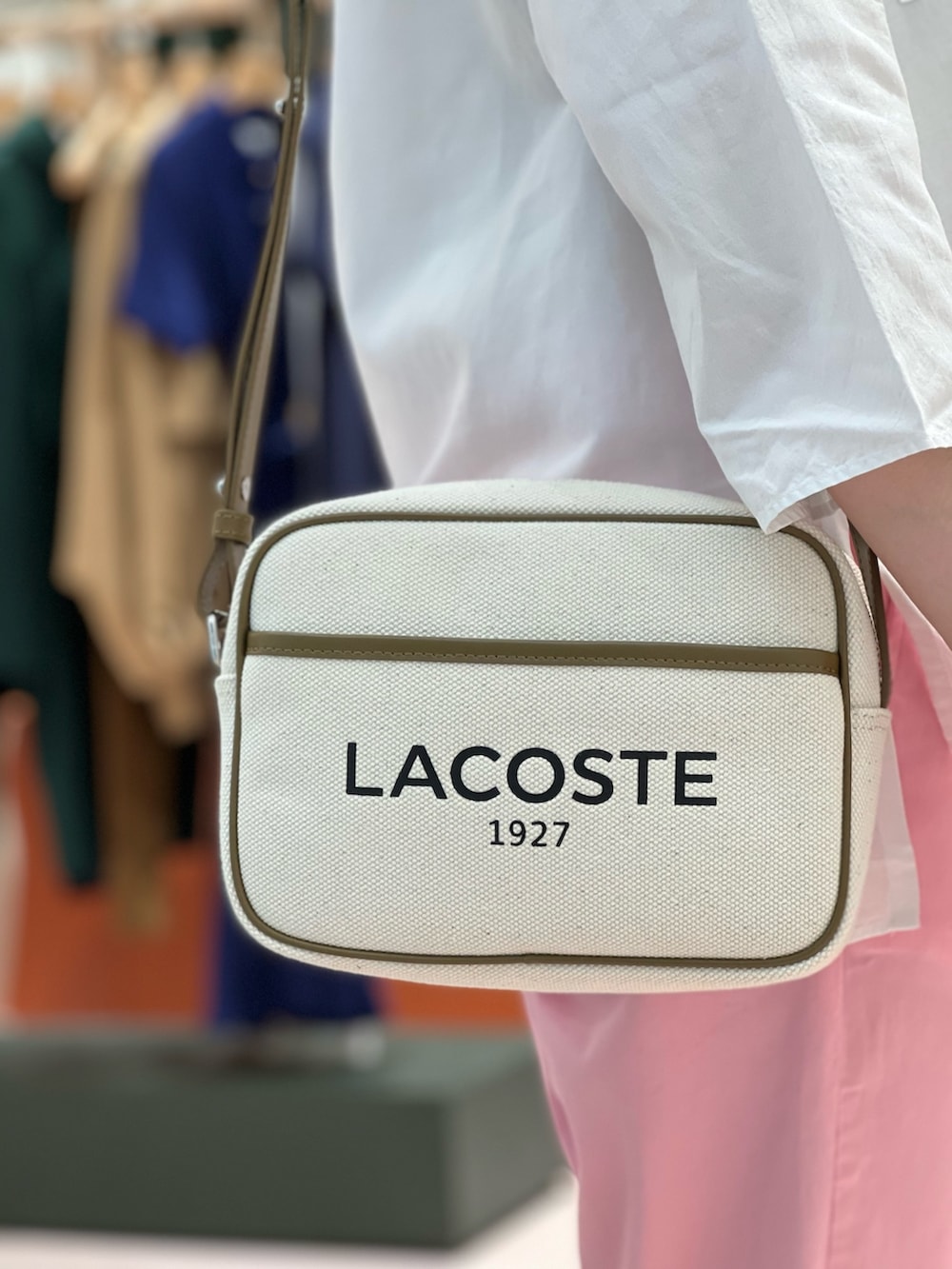 ホワイト系のスニーカー、ピンク系のパンツ、ベージュ系のショルダーバッグを着用したレディースの春コーディネートの3枚目の写真