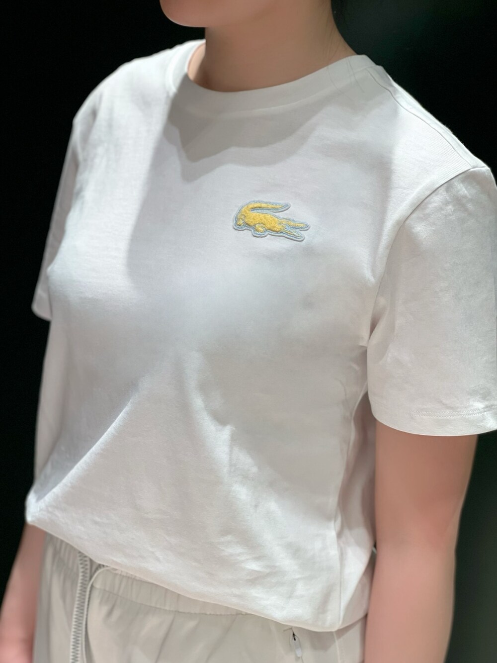 ホワイト系のスニーカー、ホワイト系のスウェットパンツ、ベージュ系のステンカラーコートを着用したレディースの春コーディネートの5枚目の写真