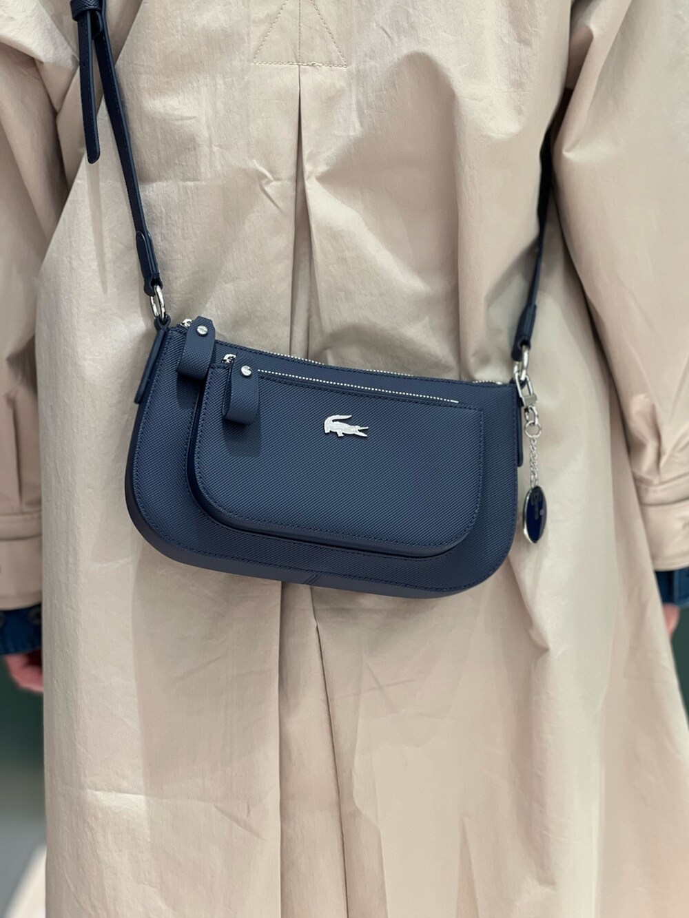 ホワイト系のスニーカー、ホワイト系のスウェットパンツ、ベージュ系のステンカラーコートを着用したレディースの春コーディネートの7枚目の写真