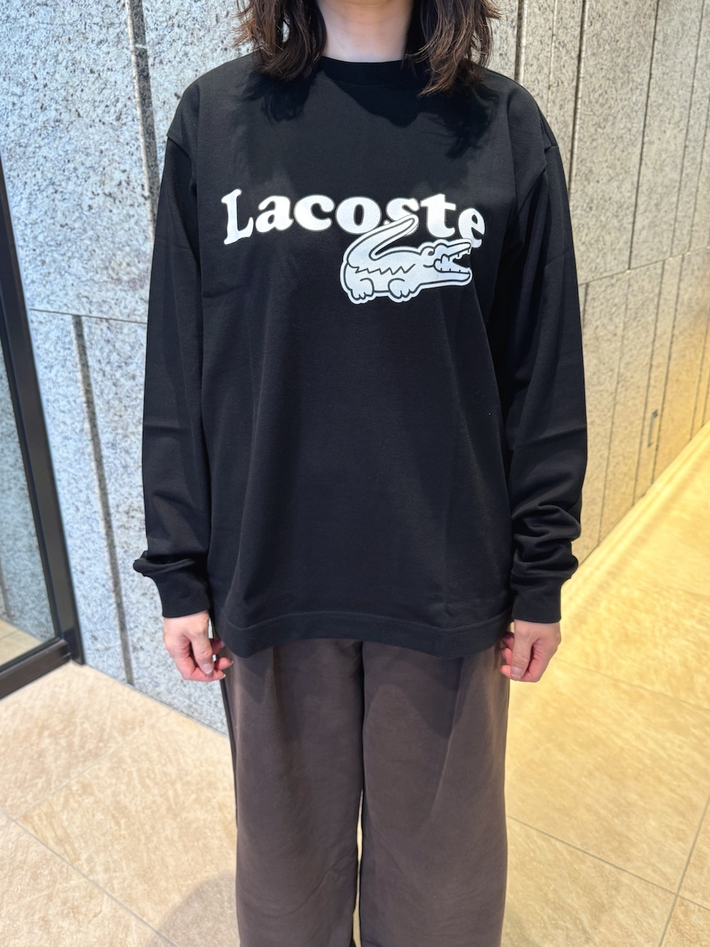 ブラック系のTシャツ/カットソー、ブラウン系のスウェットパンツ、ブラック系のスニーカーを着用したレディースの秋コーディネートの4枚目の写真