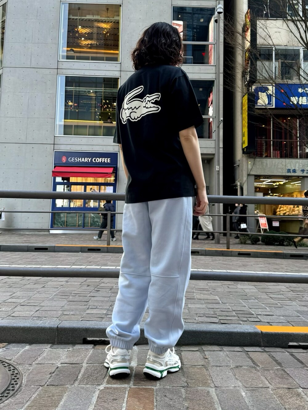 ブルー系のスウェットパンツ、ホワイト系のスニーカー、ブラック系のTシャツ/カットソーを着用したレディースの春コーディネートの2枚目の写真