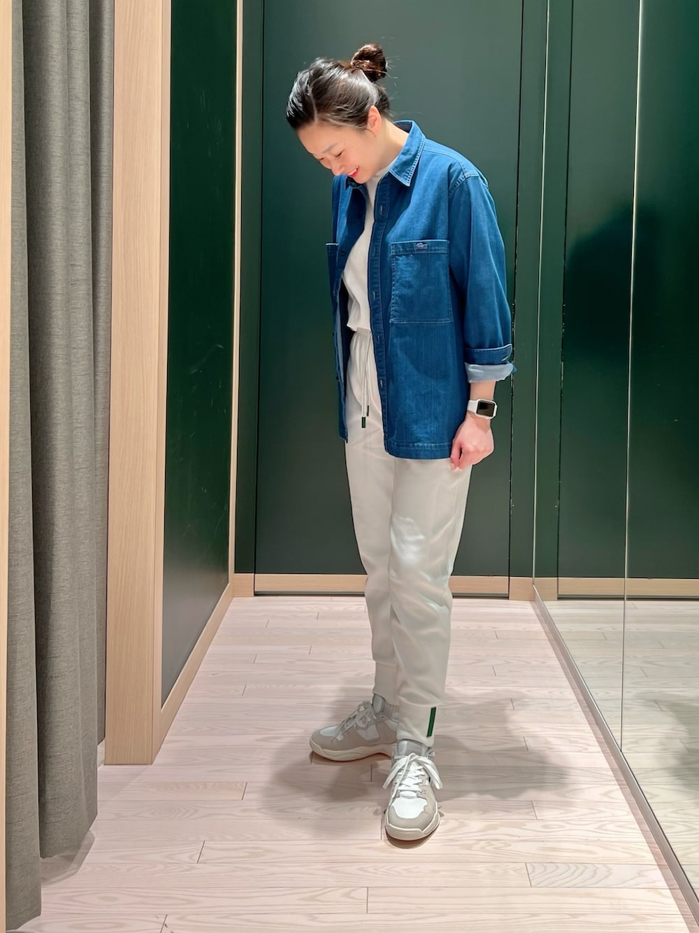 ホワイト系のスニーカー、ホワイト系のスウェットパンツ、ベージュ系のステンカラーコートを着用したレディースの春コーディネートの2枚目の写真