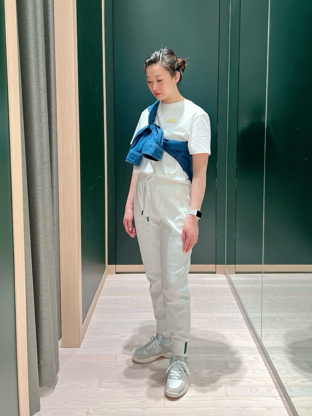 ホワイト系のスニーカー、ホワイト系のスウェットパンツ、ベージュ系のステンカラーコートを着用したレディースの春コーディネートの3枚目の写真