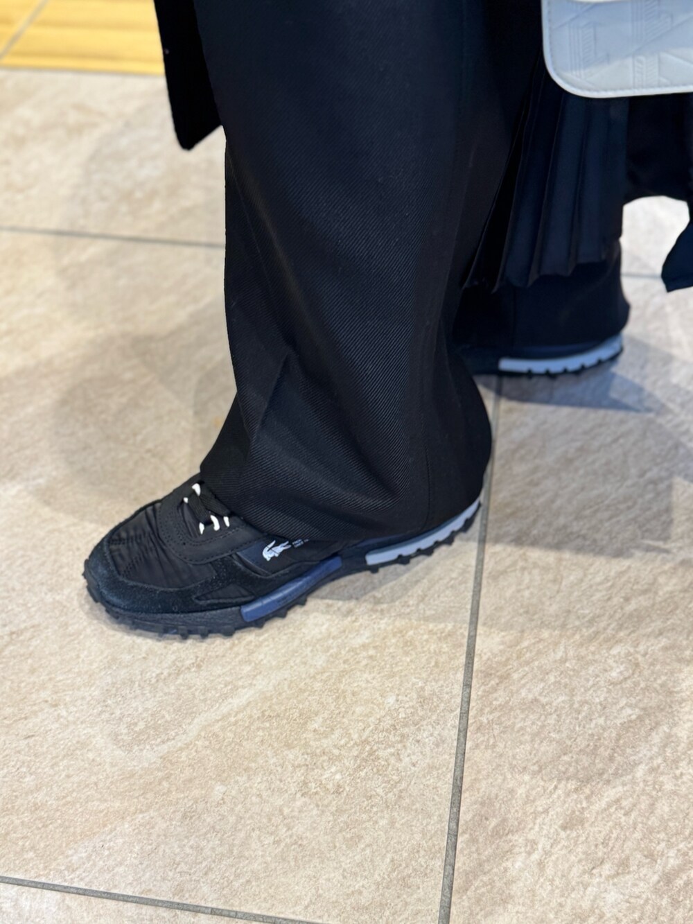 ブラック系のジャケット/アウター、ホワイト系のメッセンジャーバッグ、ブラック系のスニーカーを着用したレディースの冬コーディネートの6枚目の写真