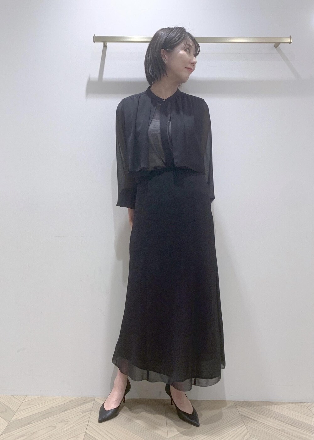 ブラック系のパンプス、ブラック系のシャツ/ブラウス、ブラック系のスカートを着用したレディースの春コーディネートの3枚目の写真