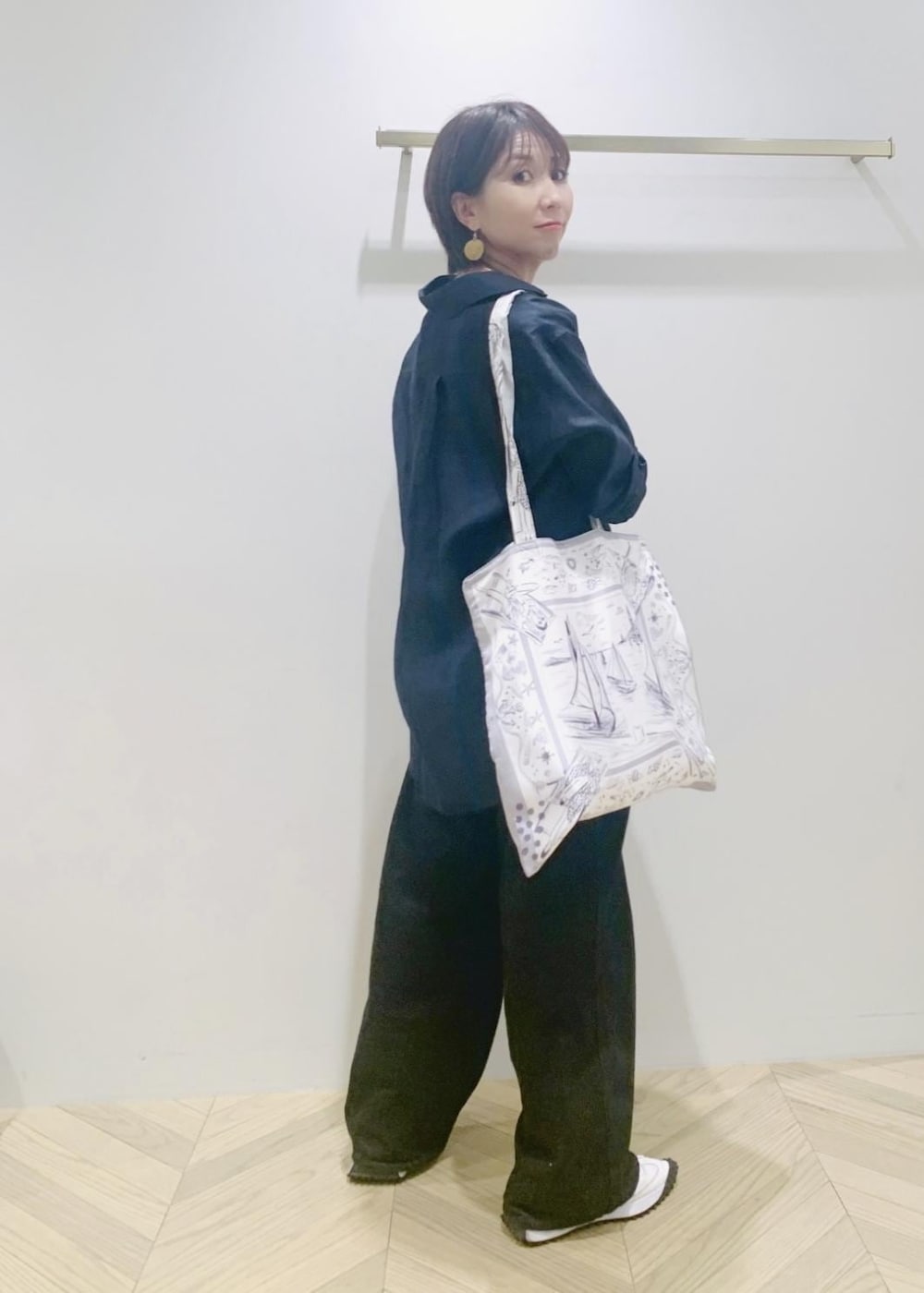 ブラック系のデニムパンツ、ブルー系のシャツ/ブラウス、ホワイト系のトートバッグを着用したレディースの夏コーディネートの2枚目の写真