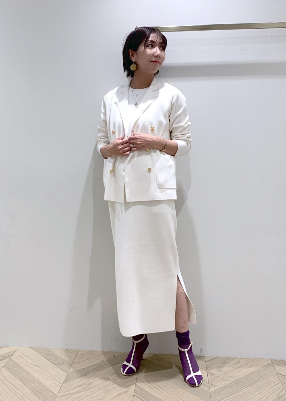 ホワイト系のサンダル、ホワイト系のワンピース、ホワイト系のテーラードジャケットを着用したレディースの春コーディネートの2枚目の写真