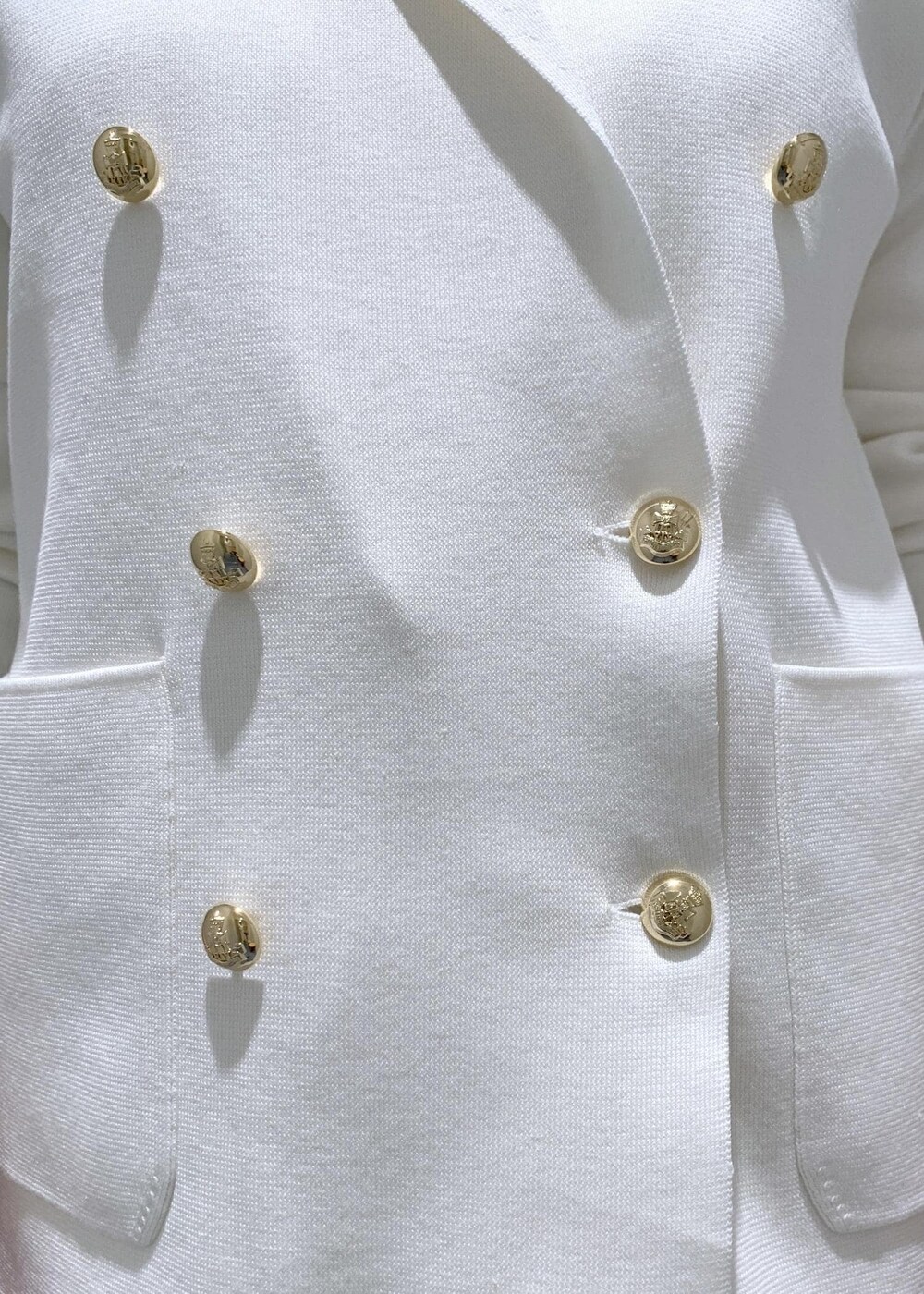 ホワイト系のサンダル、ホワイト系のワンピース、ホワイト系のテーラードジャケットを着用したレディースの春コーディネートの4枚目の写真