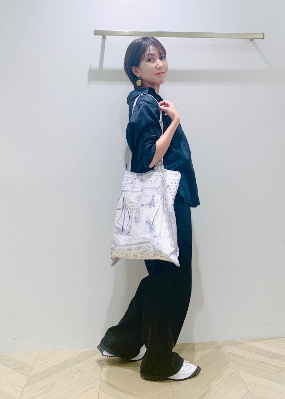 ブラック系のデニムパンツ、ブルー系のシャツ/ブラウス、ホワイト系のトートバッグを着用したレディースの夏コーディネートの4枚目の写真