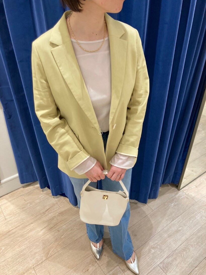 イエロー系のテーラードジャケット、ブルー系のデニムパンツ、ゴールド系のパンプスを着用したレディースの春コーディネートの8枚目の写真