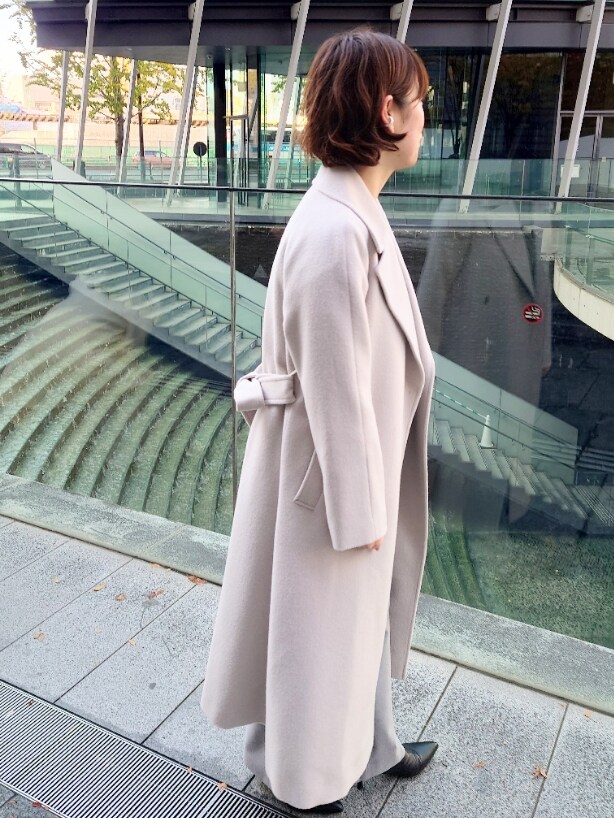 ベージュ系のその他アウター、グレー系のニット/セーター、グレー系のその他パンツを着用したレディースの冬コーディネートの4枚目の写真