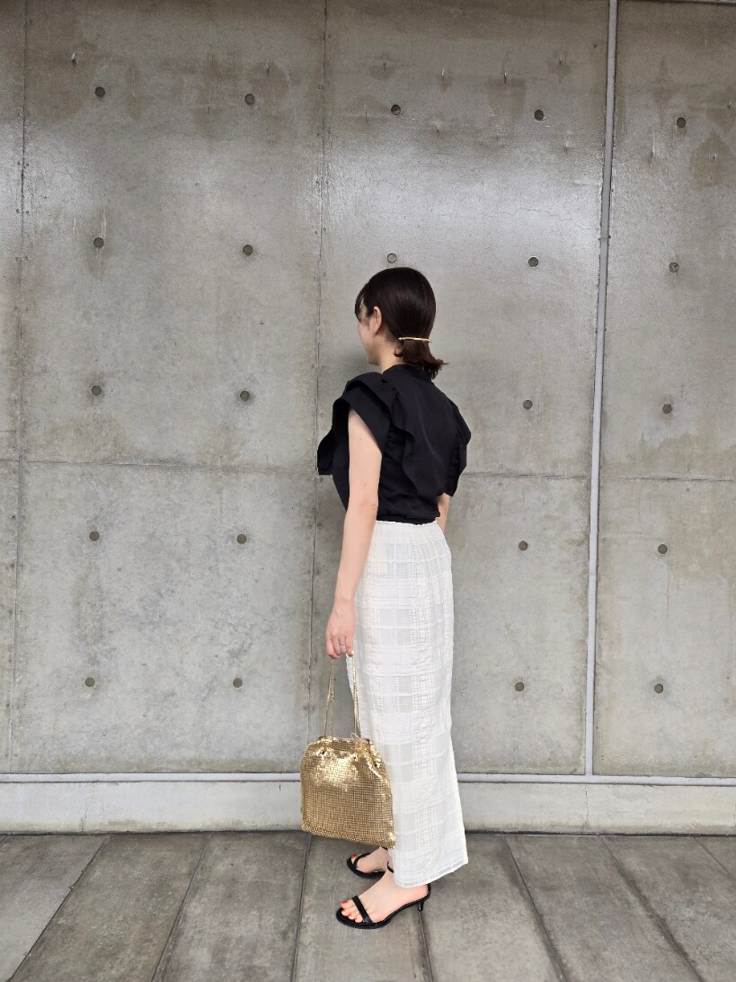 ブラック系のシャツ/ブラウス、ホワイト系のスカート、ゴールド系のショルダーバッグを着用したレディースの夏コーディネートの2枚目の写真