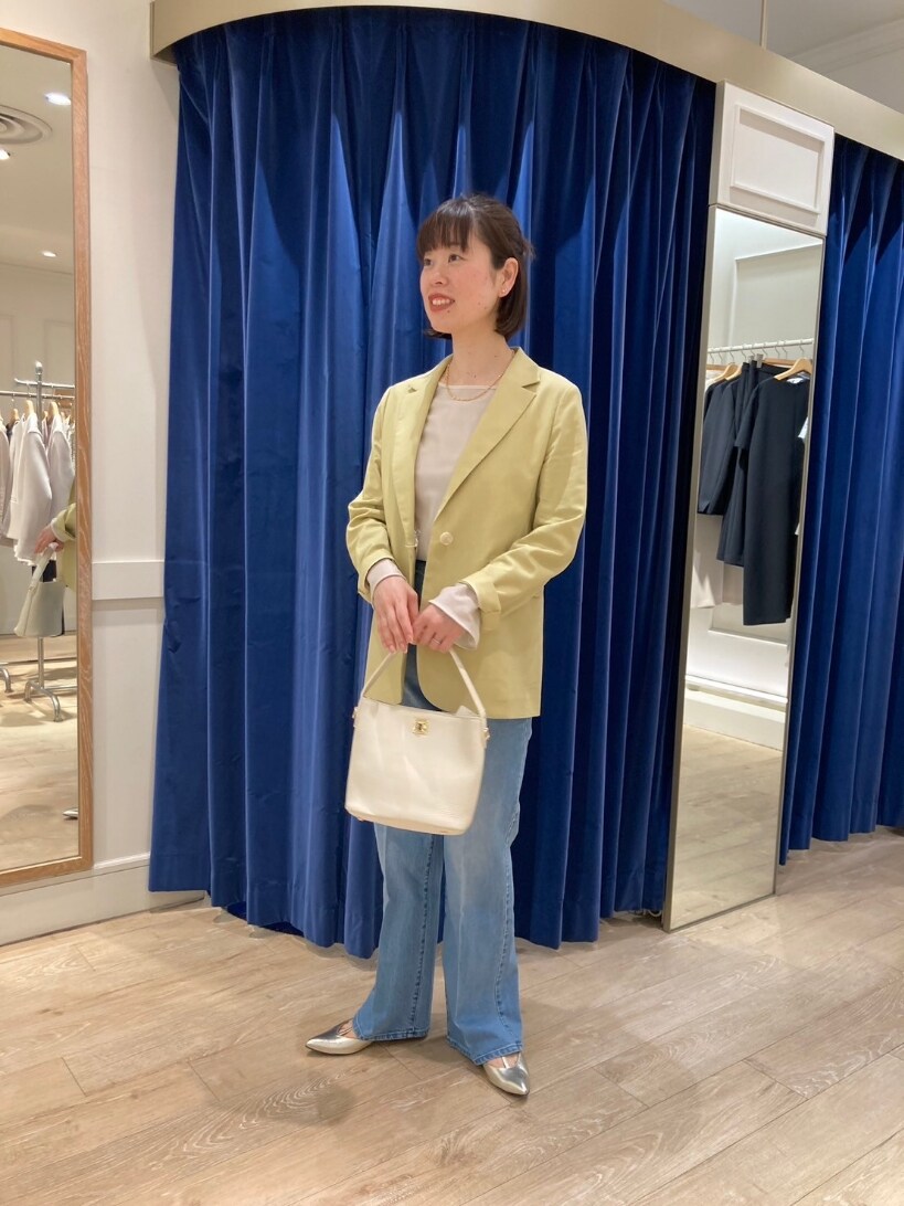 イエロー系のテーラードジャケット、ブルー系のデニムパンツ、ゴールド系のパンプスを着用したレディースの春コーディネートの5枚目の写真