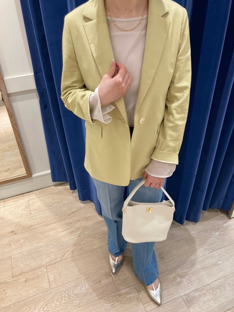 イエロー系のテーラードジャケット、ブルー系のデニムパンツ、ゴールド系のパンプスを着用したレディースの春コーディネートの9枚目の写真