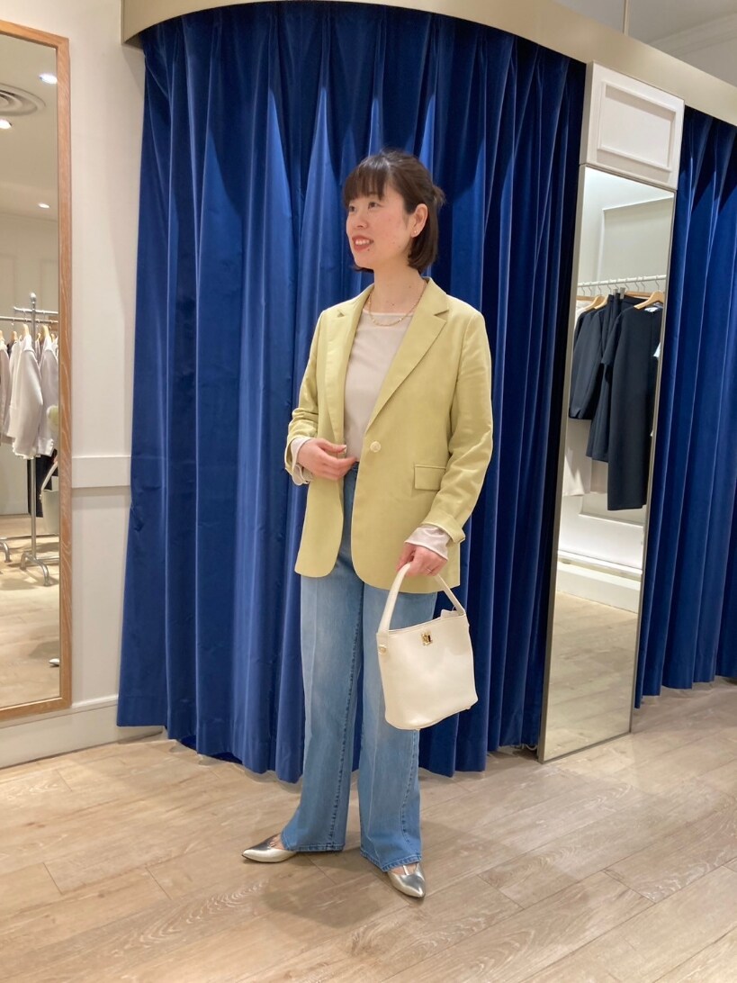 イエロー系のテーラードジャケット、ブルー系のデニムパンツ、ゴールド系のパンプスを着用したレディースの春コーディネートの10枚目の写真