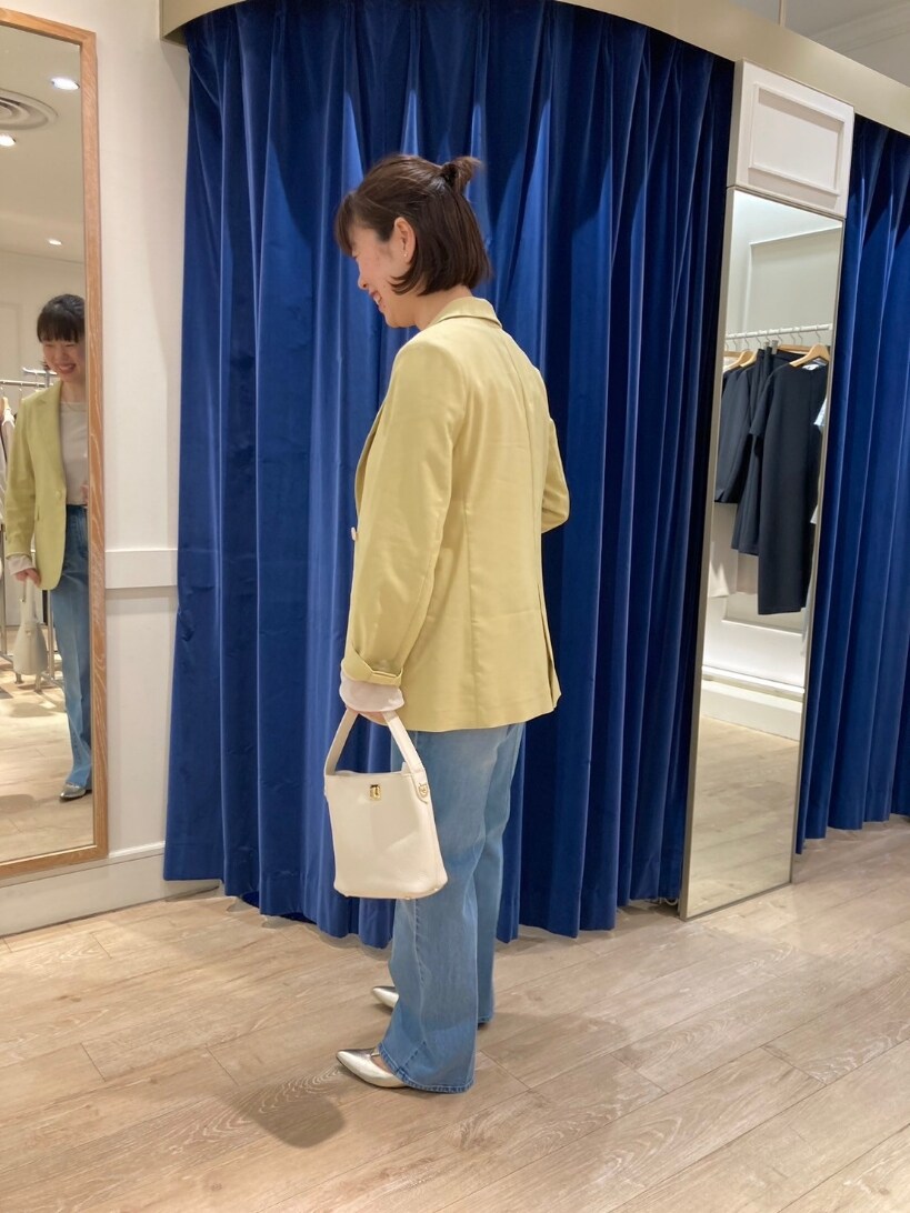 イエロー系のテーラードジャケット、ブルー系のデニムパンツ、ゴールド系のパンプスを着用したレディースの春コーディネートの7枚目の写真