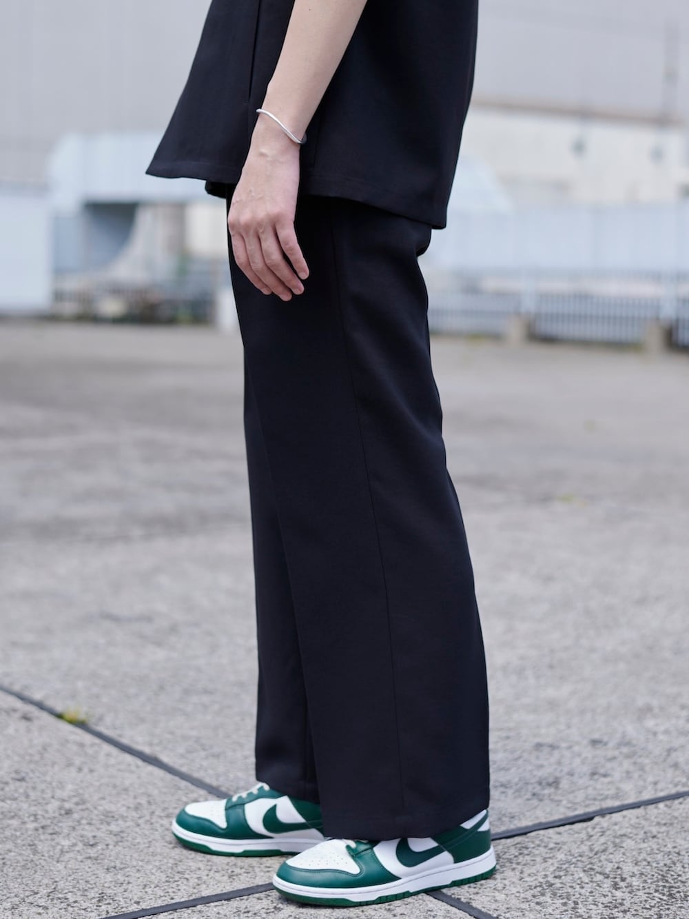 ブラック系のスラックスを着用したメンズの春コーディネートの4枚目の写真