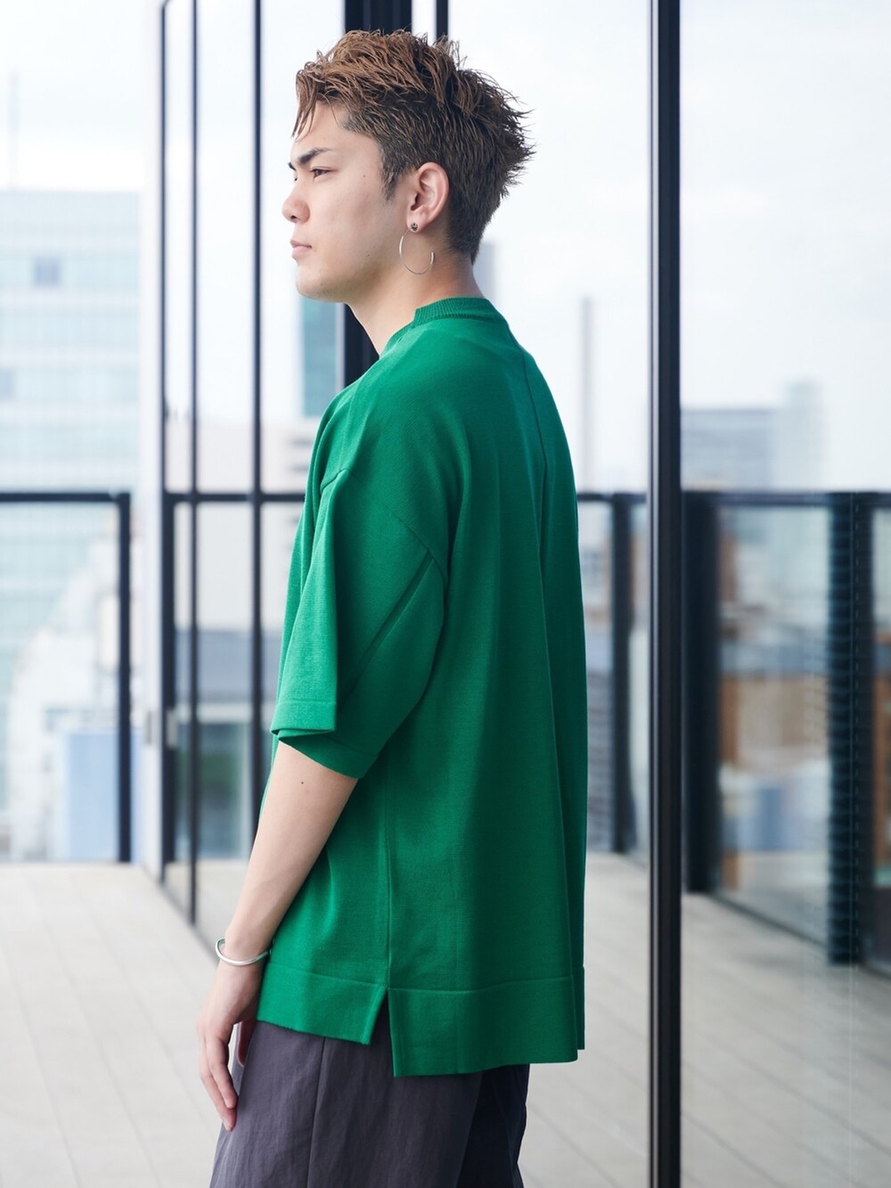 グリーン系のニット/セーターを着用したメンズの夏コーディネートの5枚目の写真