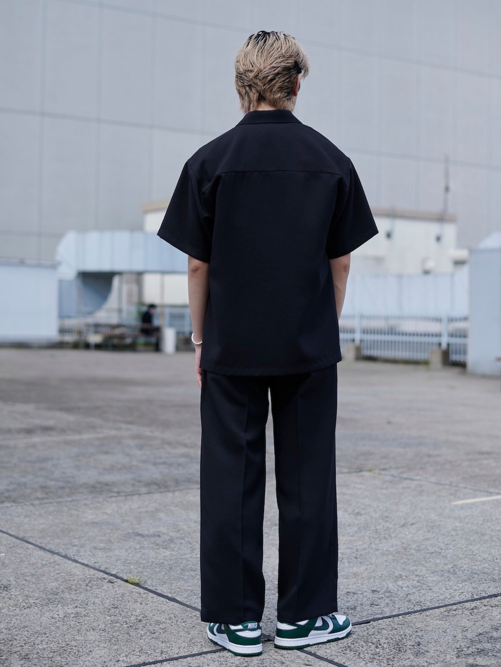 ブラック系のスラックスを着用したメンズの春コーディネートの2枚目の写真