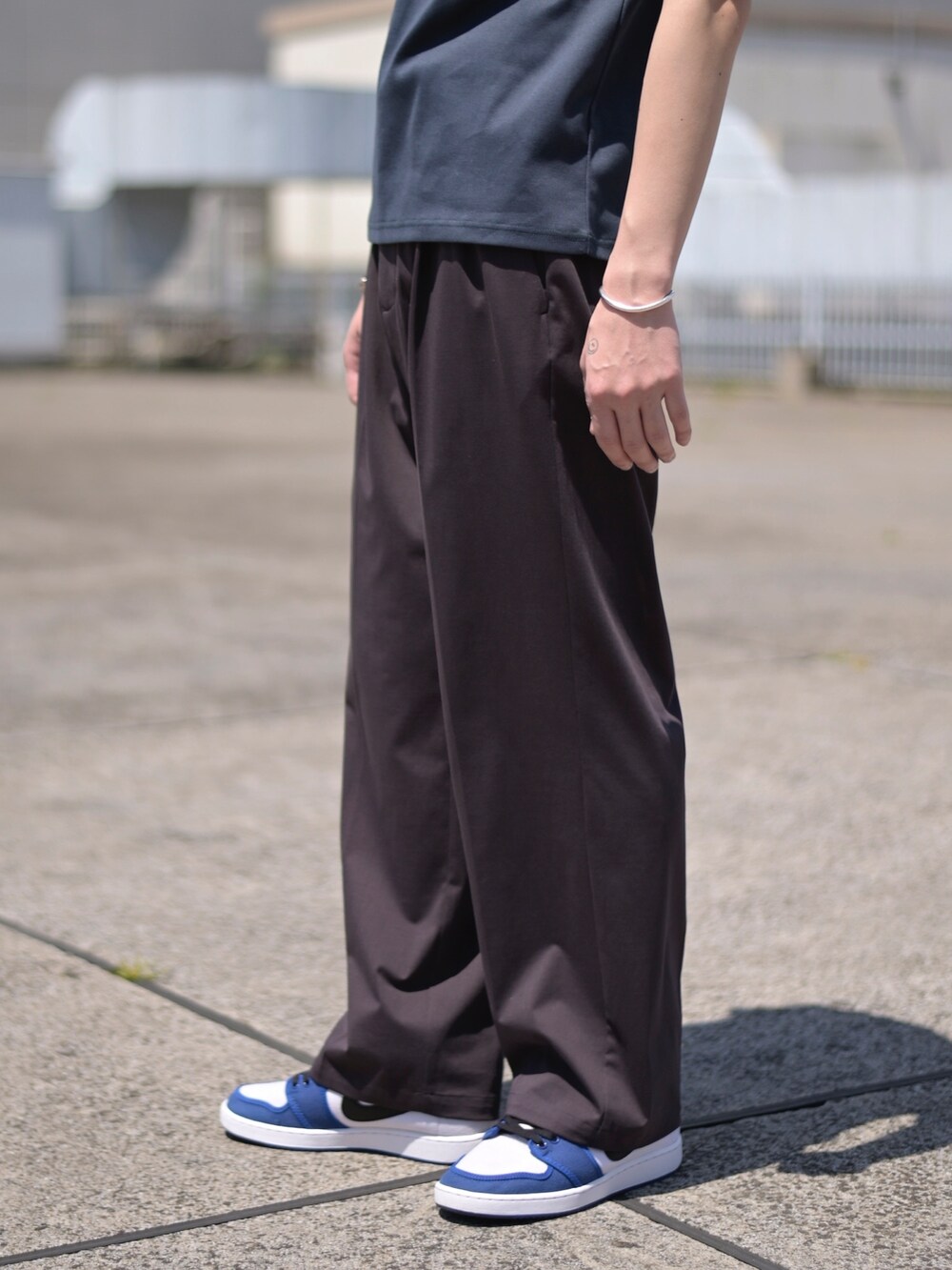 ブルー系のTシャツ/カットソー、ブラウン系のスラックスを着用したメンズの春コーディネートの4枚目の写真