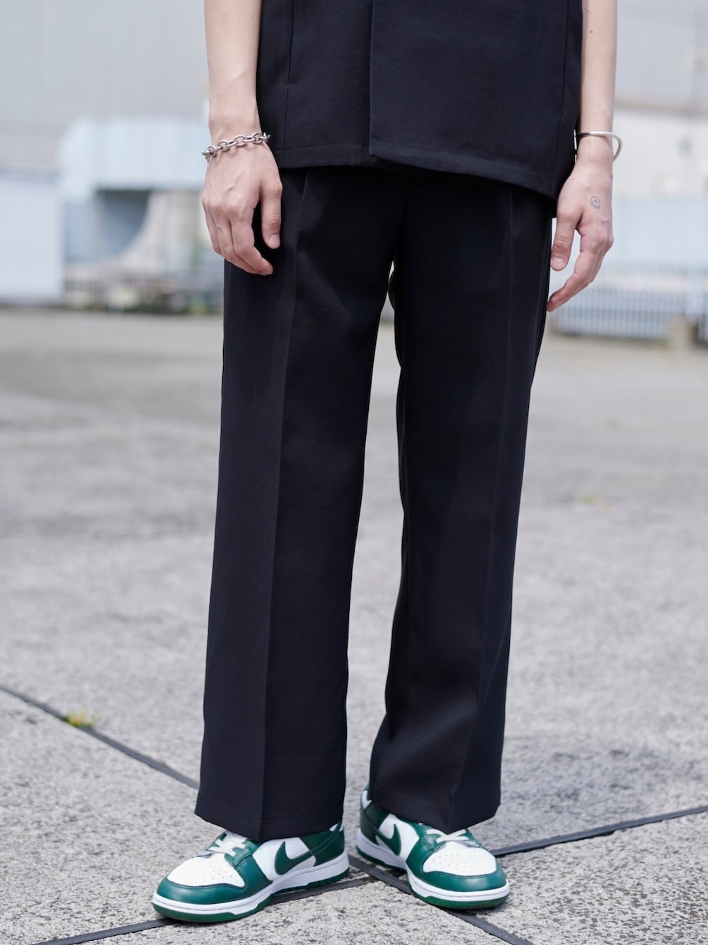 ブラック系のスラックスを着用したメンズの春コーディネートの3枚目の写真