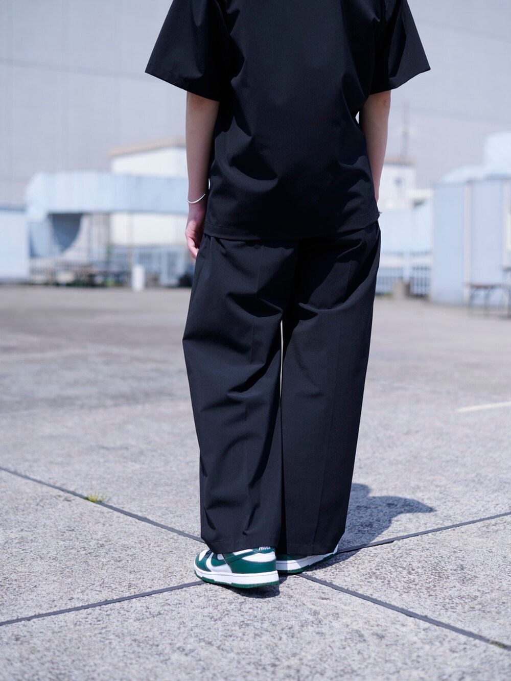 ブラック系のスラックスを着用したメンズの春コーディネートの5枚目の写真