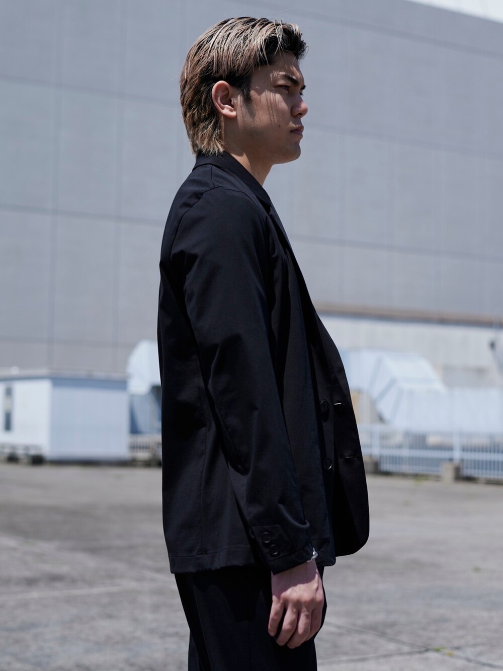 ブラック系のテーラードジャケットを着用したメンズの春コーディネートの3枚目の写真