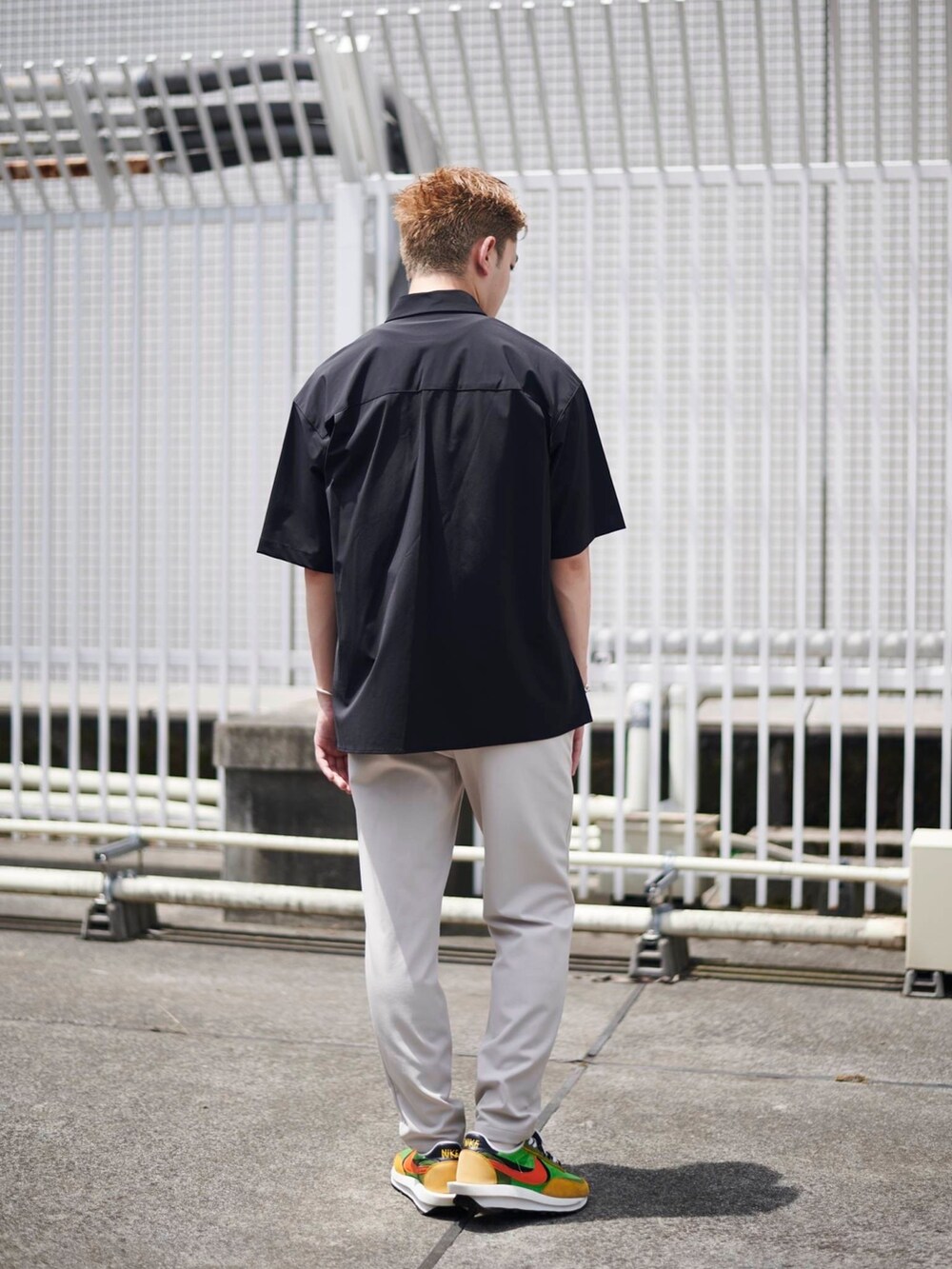 ベージュ系のスラックスを着用したメンズの夏コーディネートの2枚目の写真