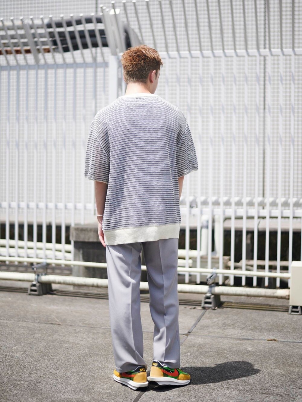 グレー系のスラックスを着用したメンズの夏コーディネートの3枚目の写真