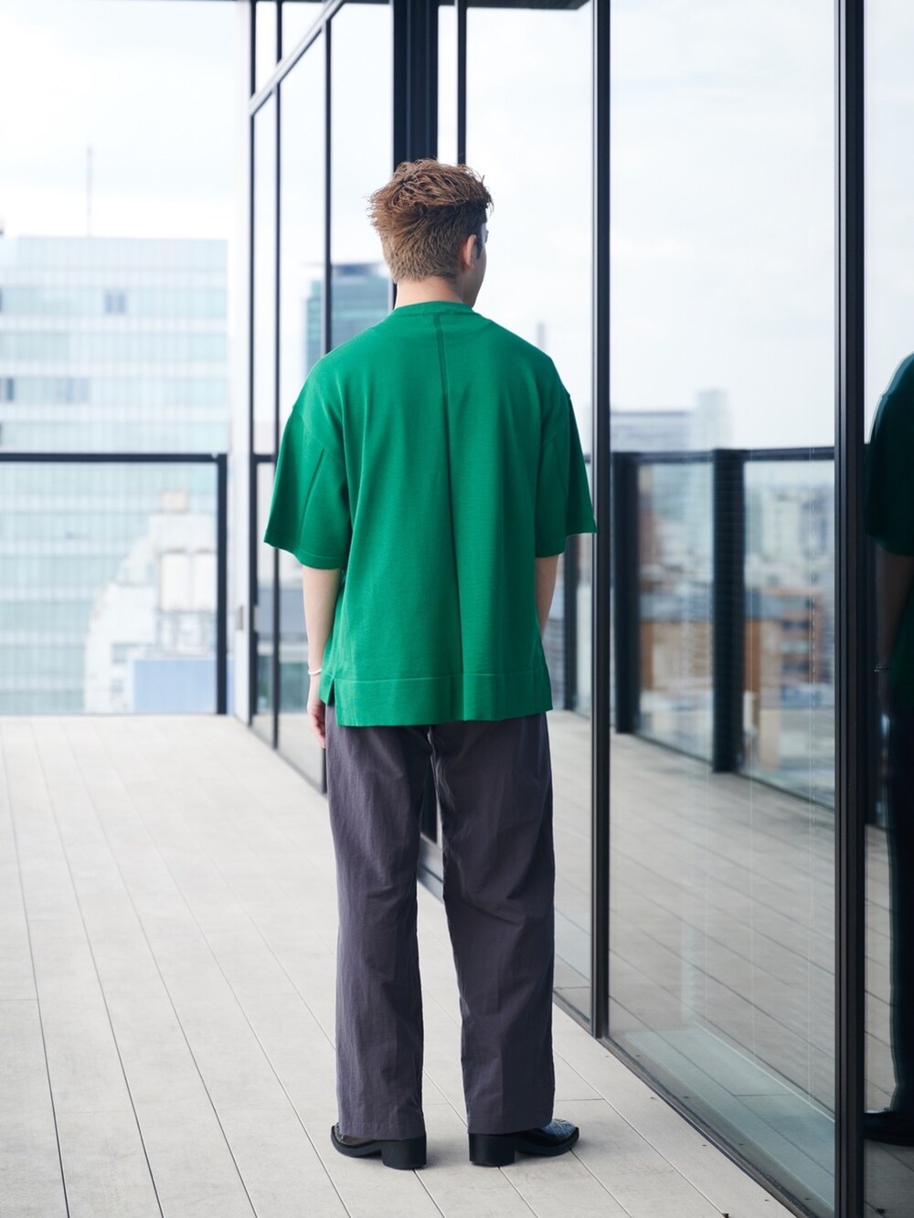 グリーン系のニット/セーターを着用したメンズの夏コーディネートの3枚目の写真