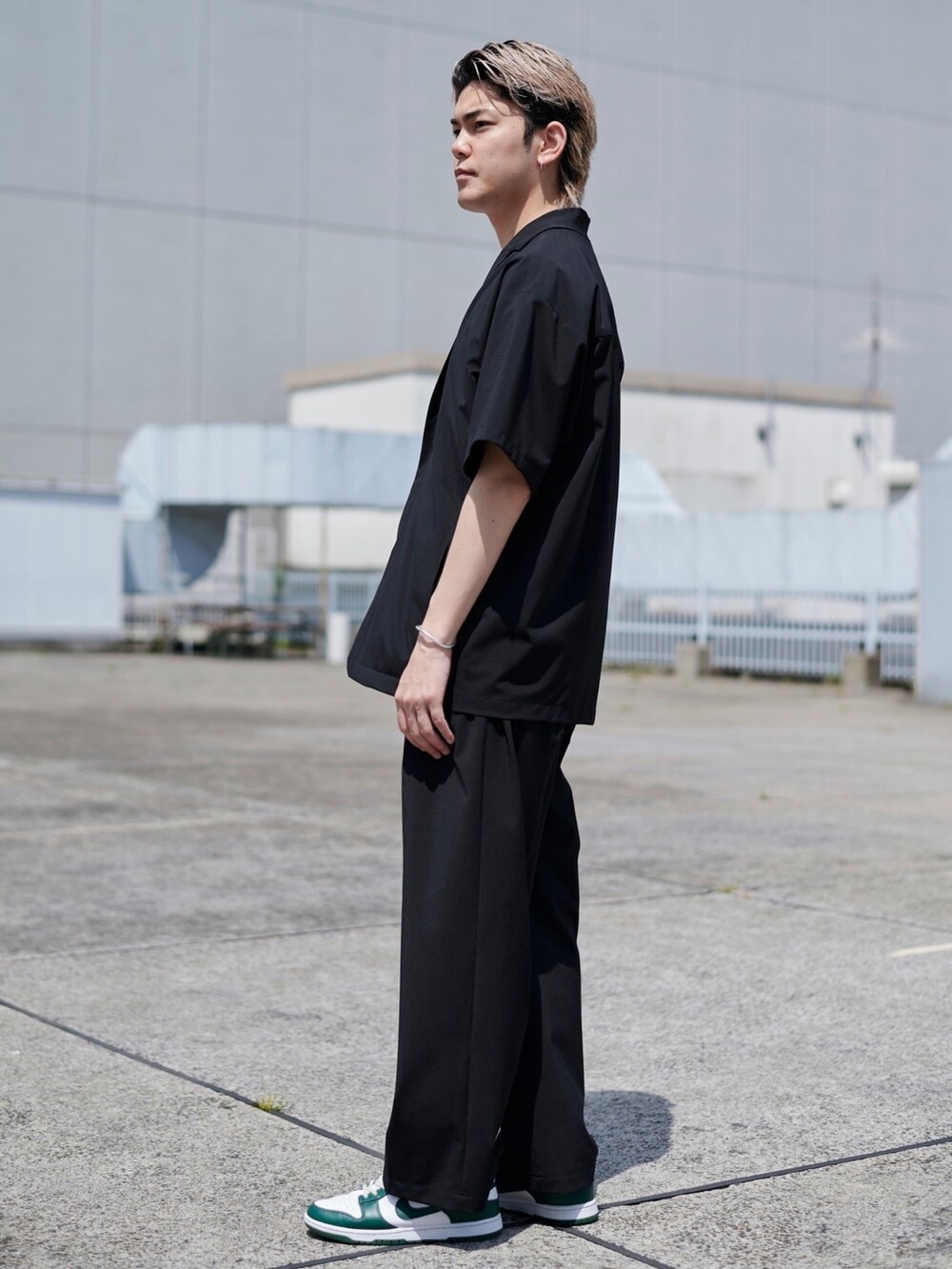 ブラック系のテーラードジャケットを着用したメンズの春コーディネートの2枚目の写真