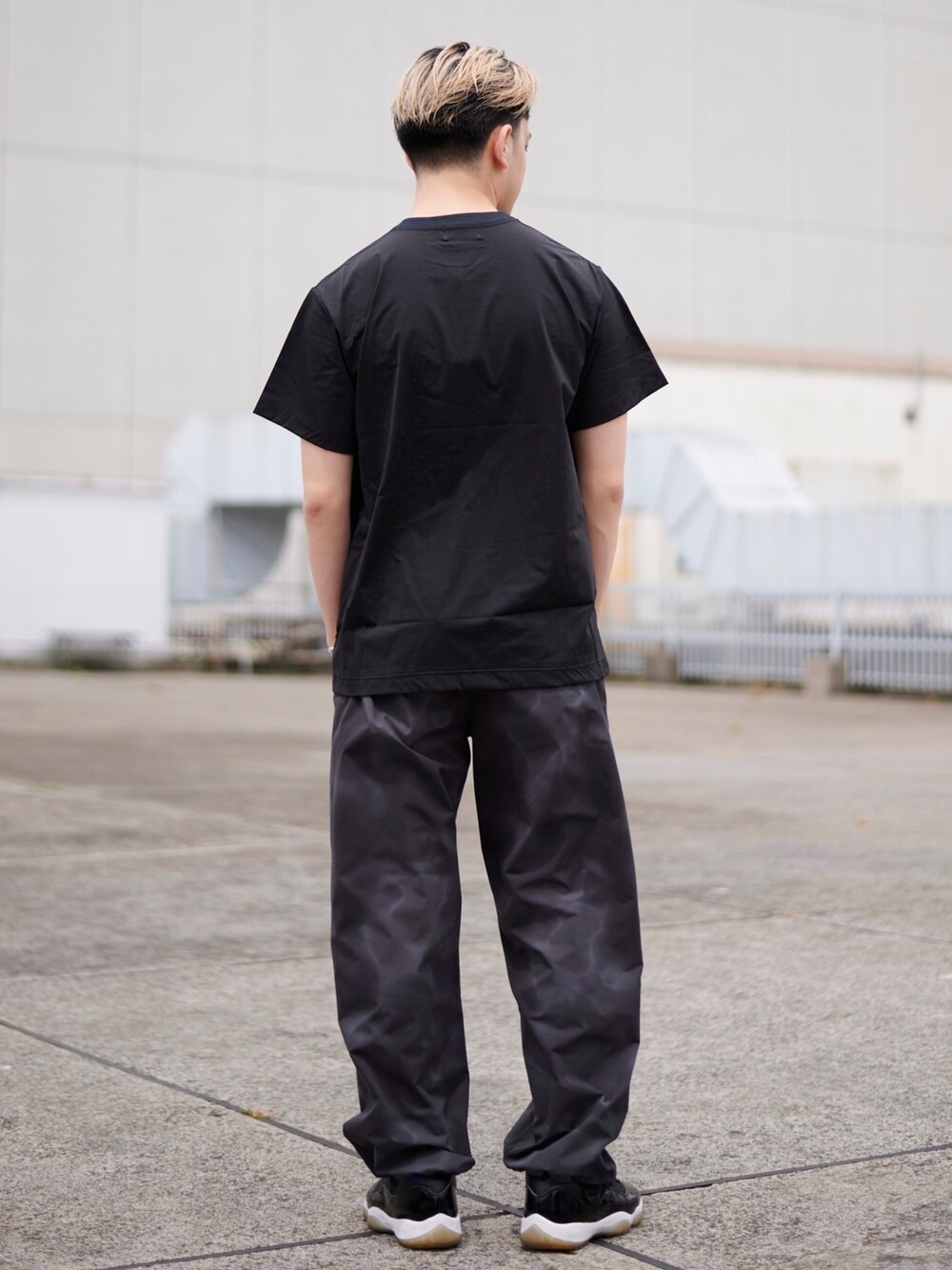 ブラック系のTシャツ/カットソーを着用したメンズの春コーディネートの3枚目の写真