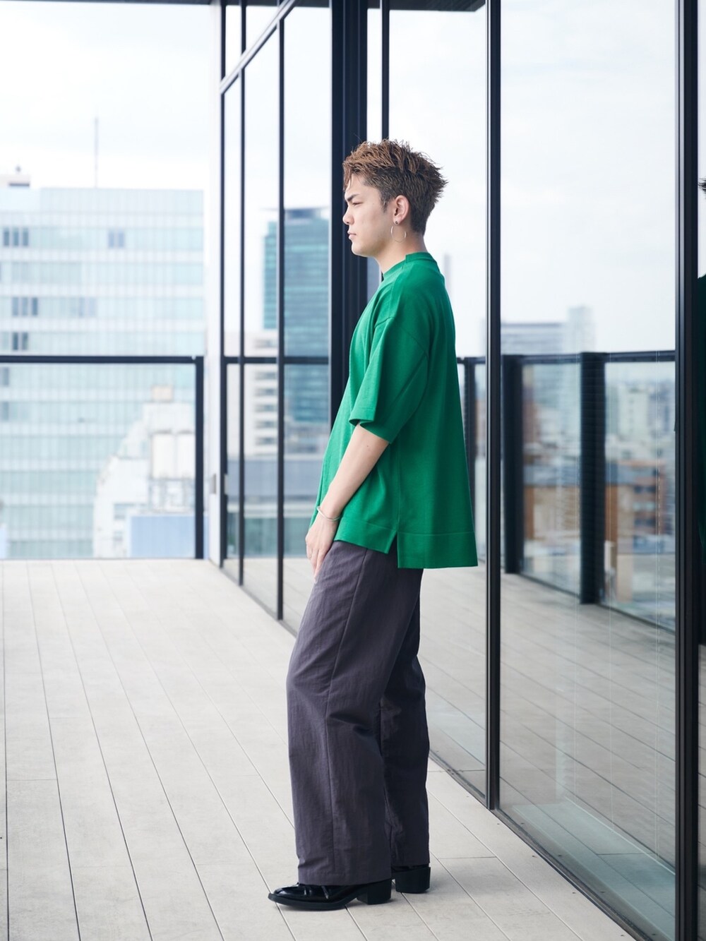 グリーン系のニット/セーターを着用したメンズの夏コーディネートの2枚目の写真