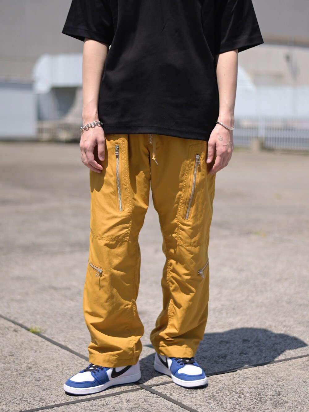 ブラック系のTシャツ/カットソー、イエロー系のカーゴパンツを着用したメンズの春コーディネートの3枚目の写真