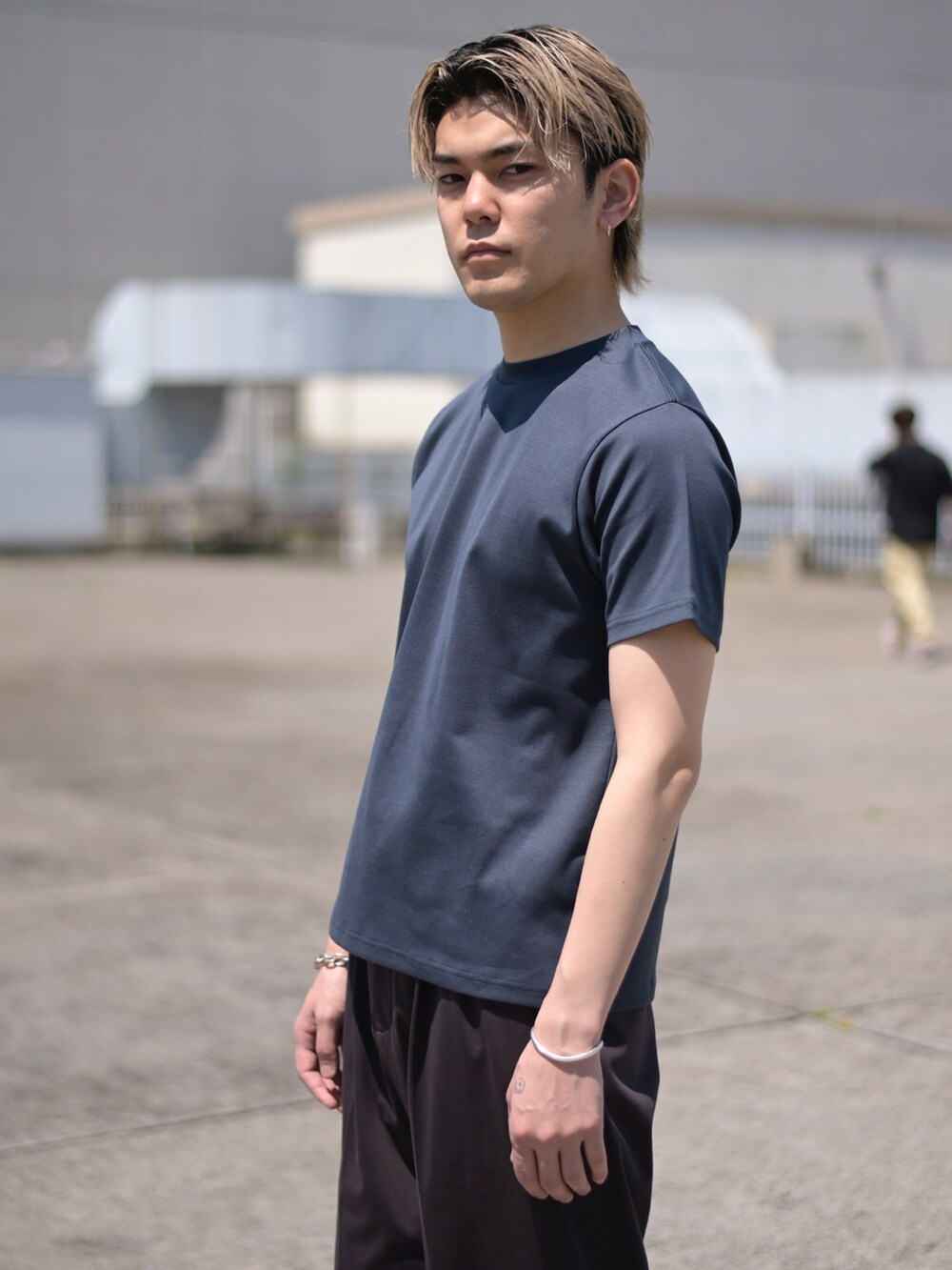 ブルー系のTシャツ/カットソー、ブラウン系のスラックスを着用したメンズの春コーディネートの2枚目の写真