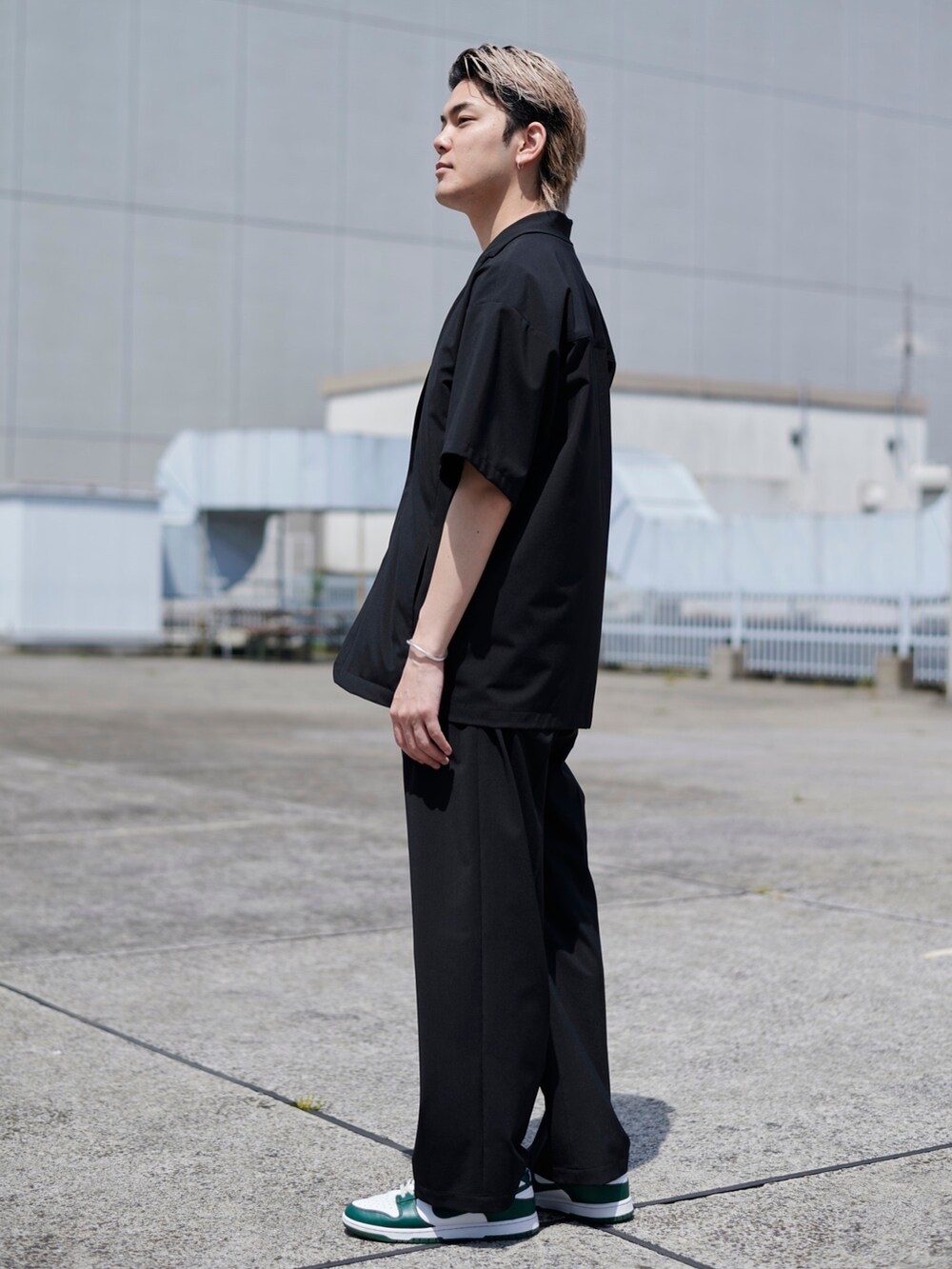 ブラック系のスラックスを着用したメンズの春コーディネートの2枚目の写真