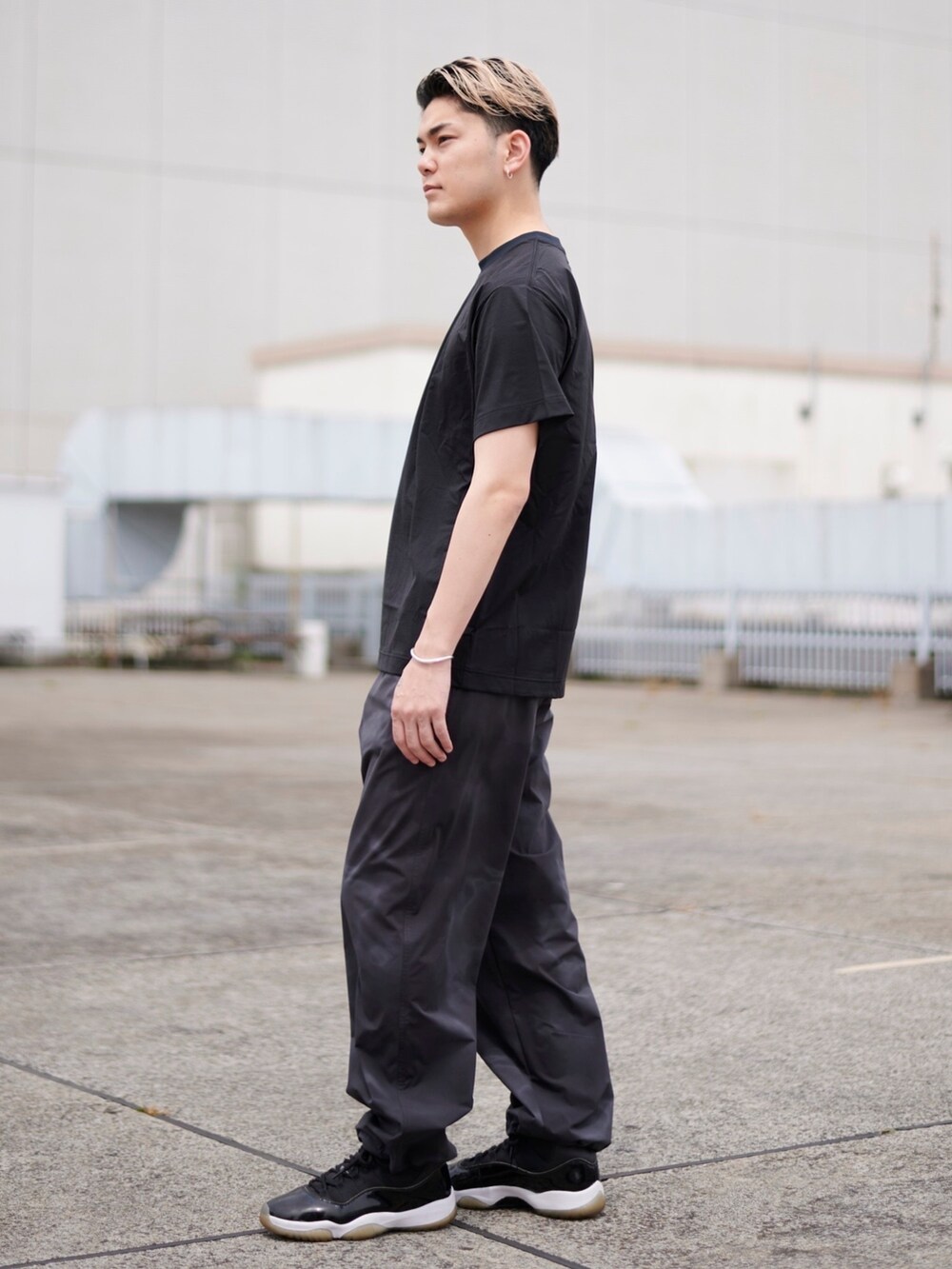 ブラック系のTシャツ/カットソーを着用したメンズの春コーディネートの2枚目の写真