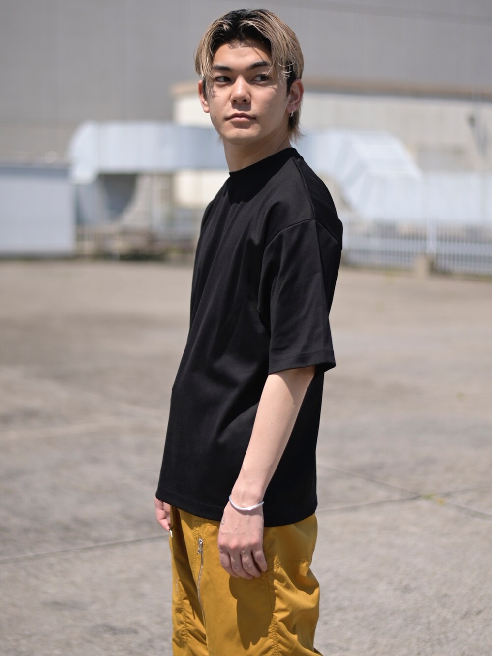 ブラック系のTシャツ/カットソー、イエロー系のカーゴパンツを着用したメンズの春コーディネートの2枚目の写真