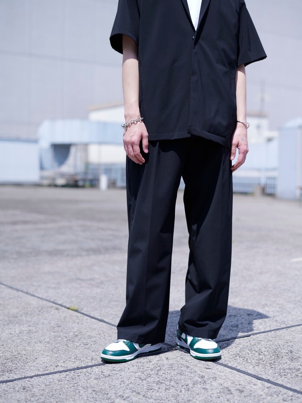 ブラック系のスラックスを着用したメンズの春コーディネートの3枚目の写真