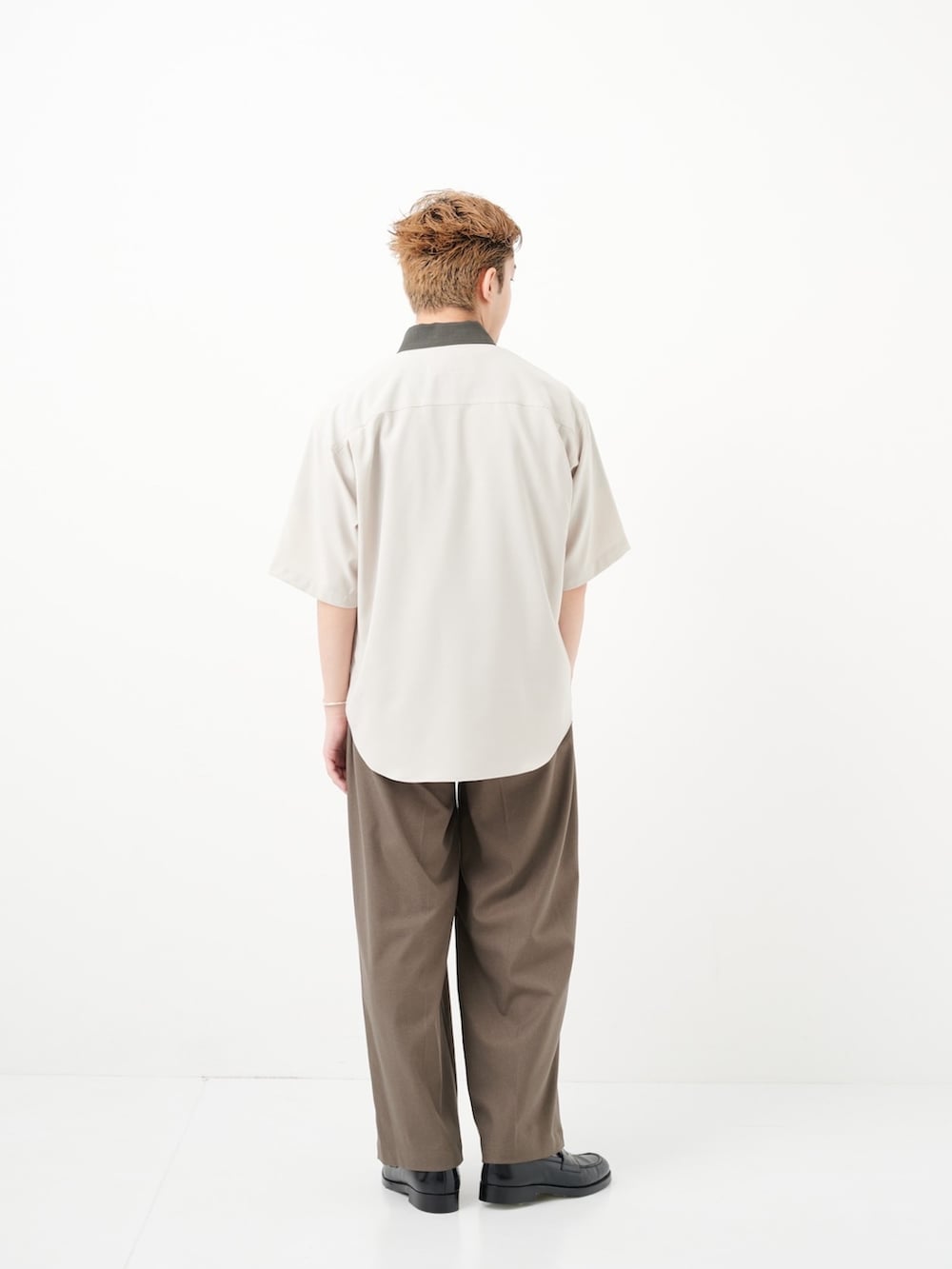 グリーン系のスラックスを着用したメンズの夏コーディネートの3枚目の写真