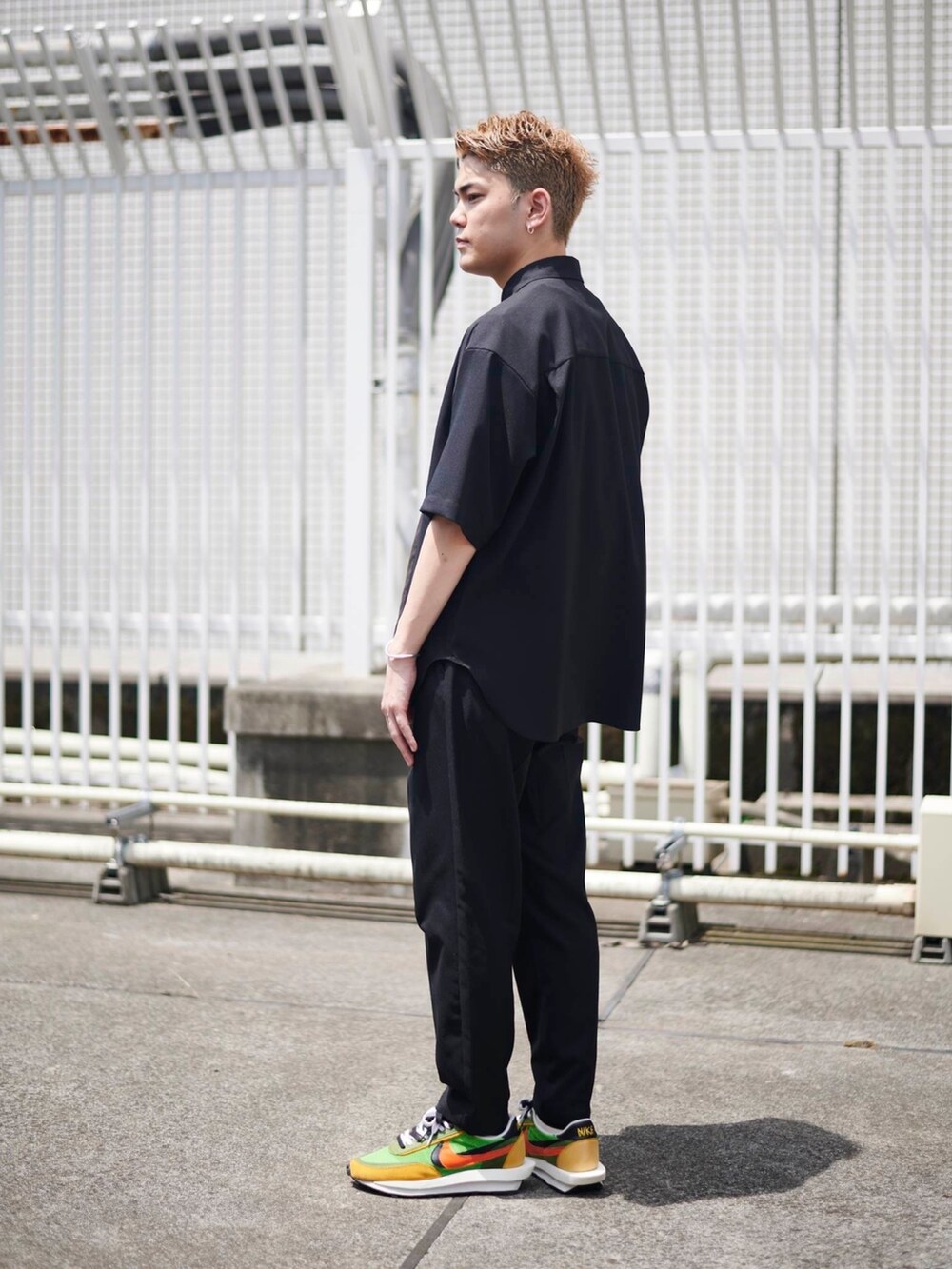 ブラック系のスラックスを着用したメンズの夏コーディネートの2枚目の写真