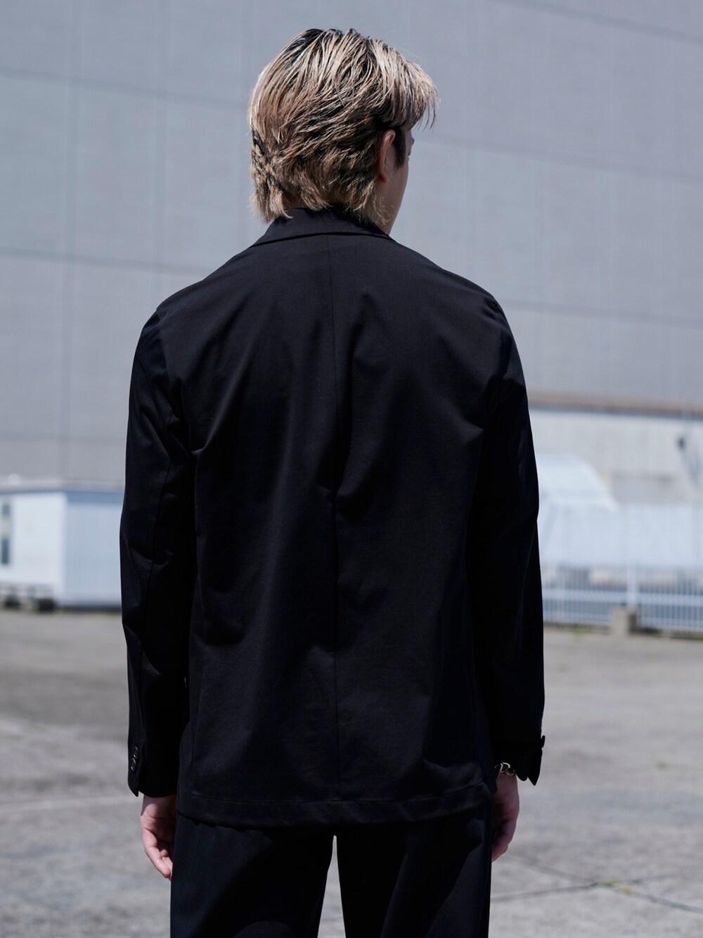 ブラック系のテーラードジャケットを着用したメンズの春コーディネートの4枚目の写真