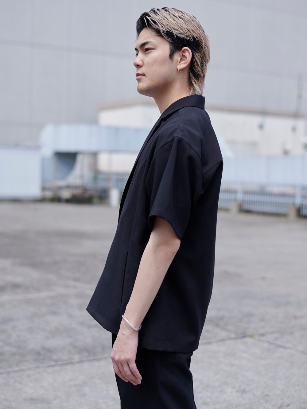 ブラック系のテーラードジャケットを着用したメンズの春コーディネートの3枚目の写真