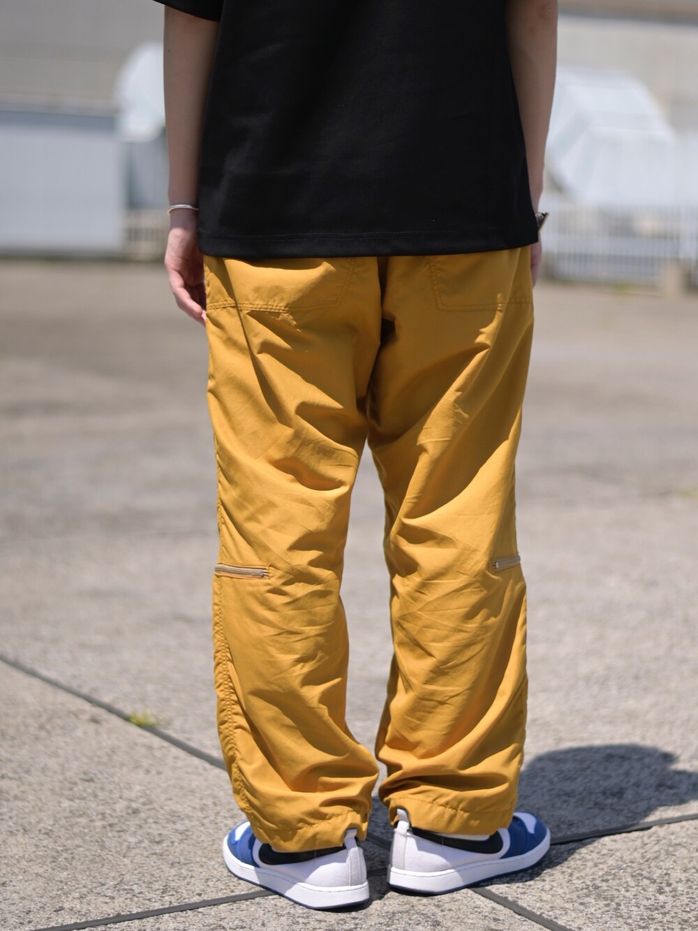 ブラック系のTシャツ/カットソー、イエロー系のカーゴパンツを着用したメンズの春コーディネートの5枚目の写真