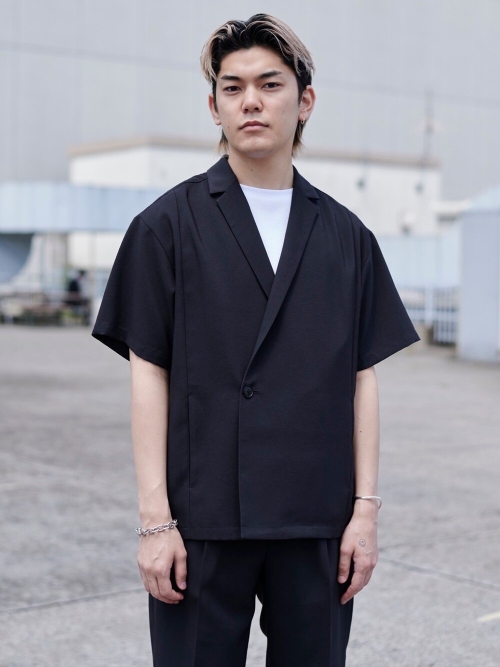 ブラック系のテーラードジャケットを着用したメンズの春コーディネートの2枚目の写真